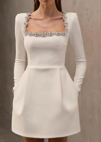 Vrouw in minijurk met strass-bloemen bij hals