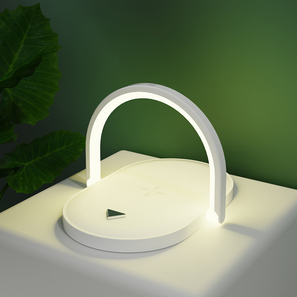 Witte bedlamp met telefoon op draadloze oplader