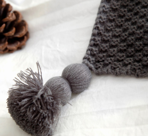 Gebreide plaid met pompons over de bank