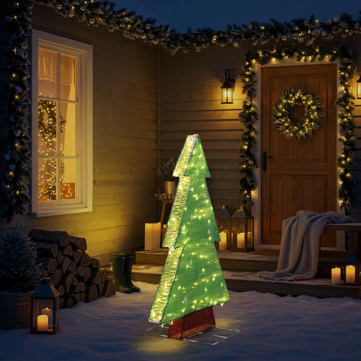 Verlichte kerstboom met sneeuwvlokken buiten