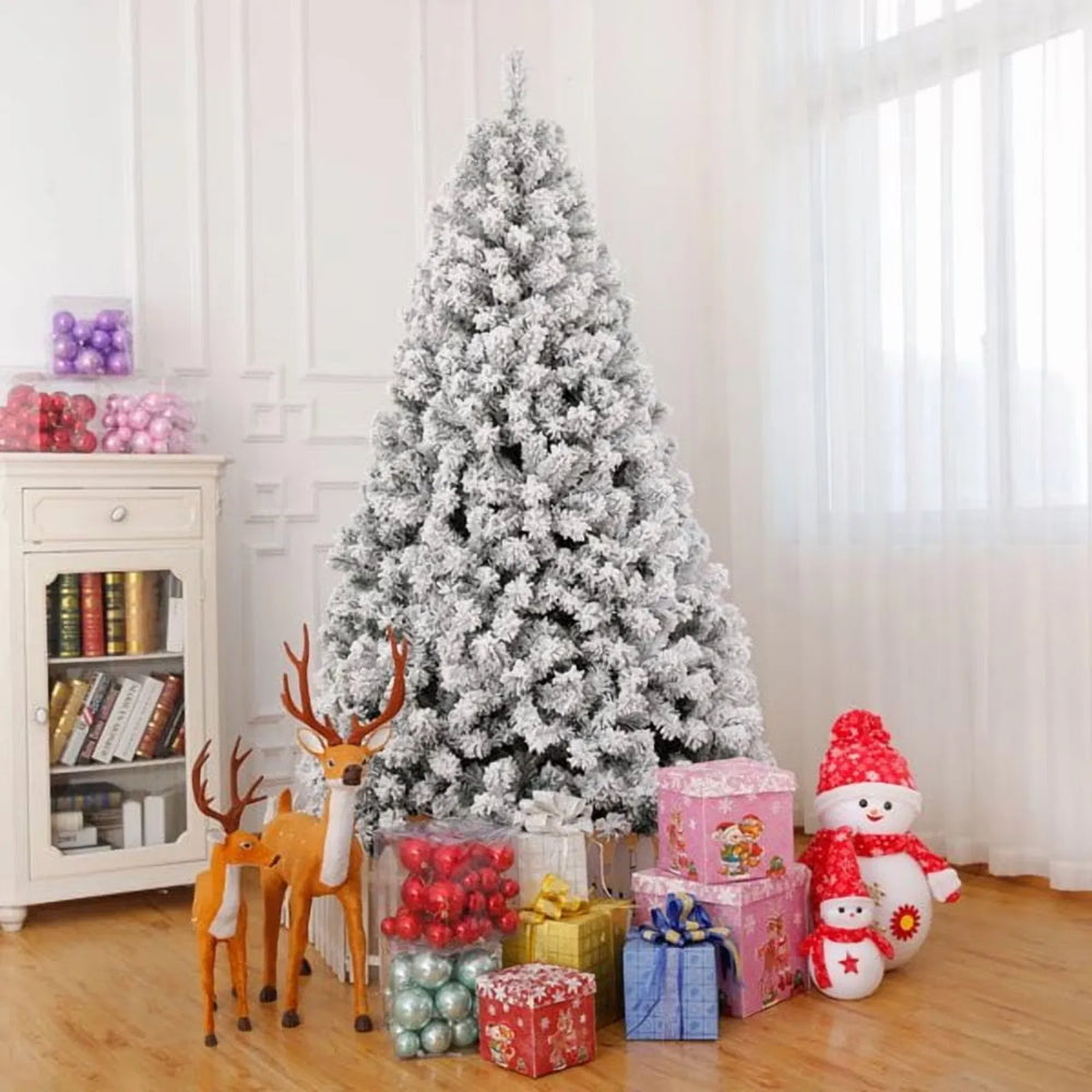 Besneeuwde kerstboom met witte lampjes