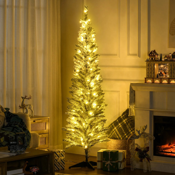 Smalle besneeuwde kerstboom met warmwitte lichtjes