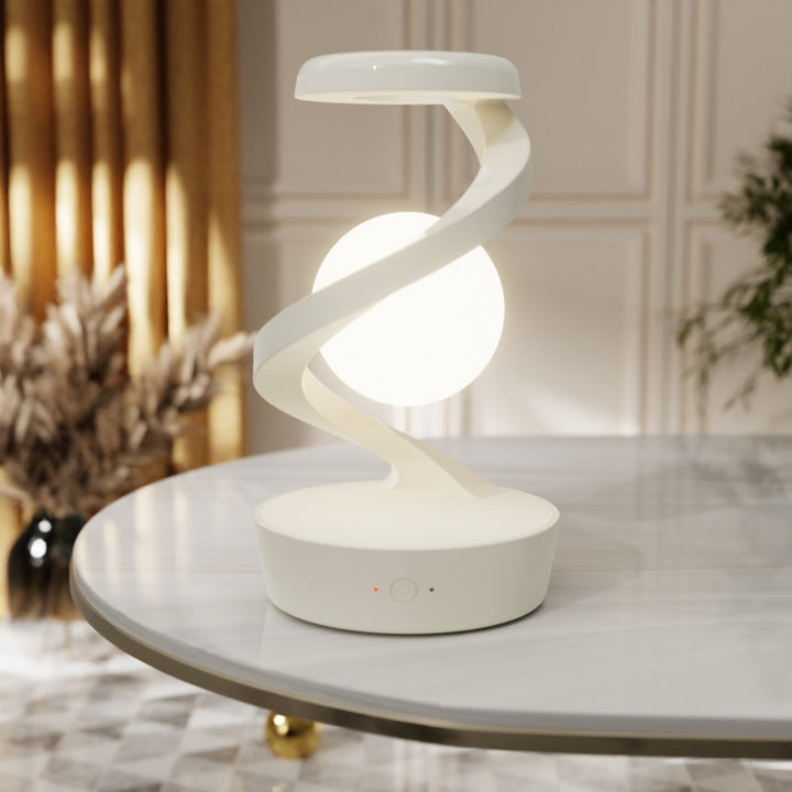Draaiende maanlamp in metalen spiraal op bureau