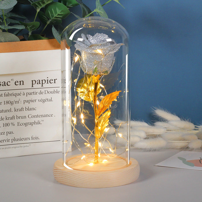 Warmtewereld Eeuwige roos in glazen stolp met goudblad en lichtjes