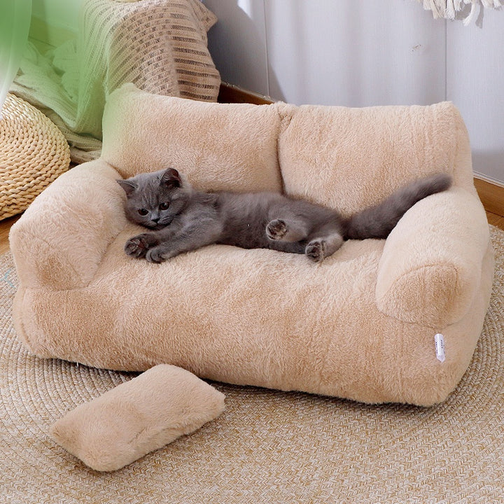 Kat ligt op een crèmekleurige pluche kattenbank