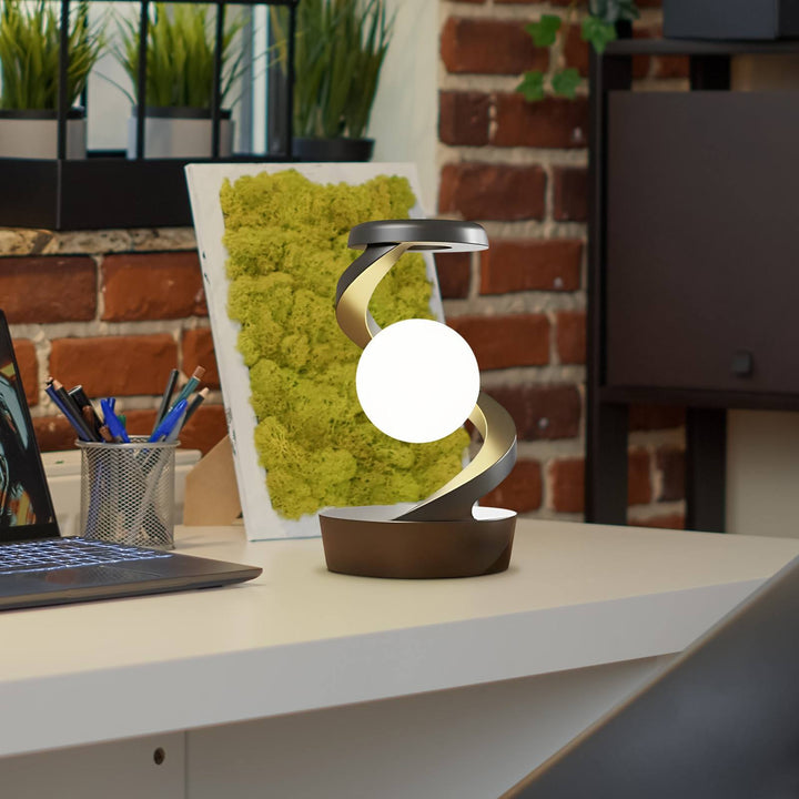 Draaiende maanlamp in metalen spiraal op bureau