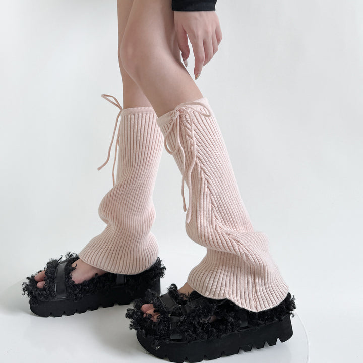 Geribde beenwarmers met strik over schoenen