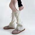 Geribde beenwarmers met strik over schoenen