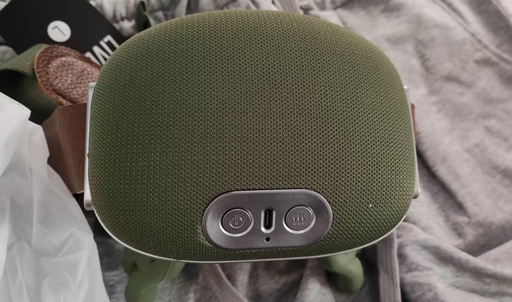 Groene snoerloze nekmassager om de schouders