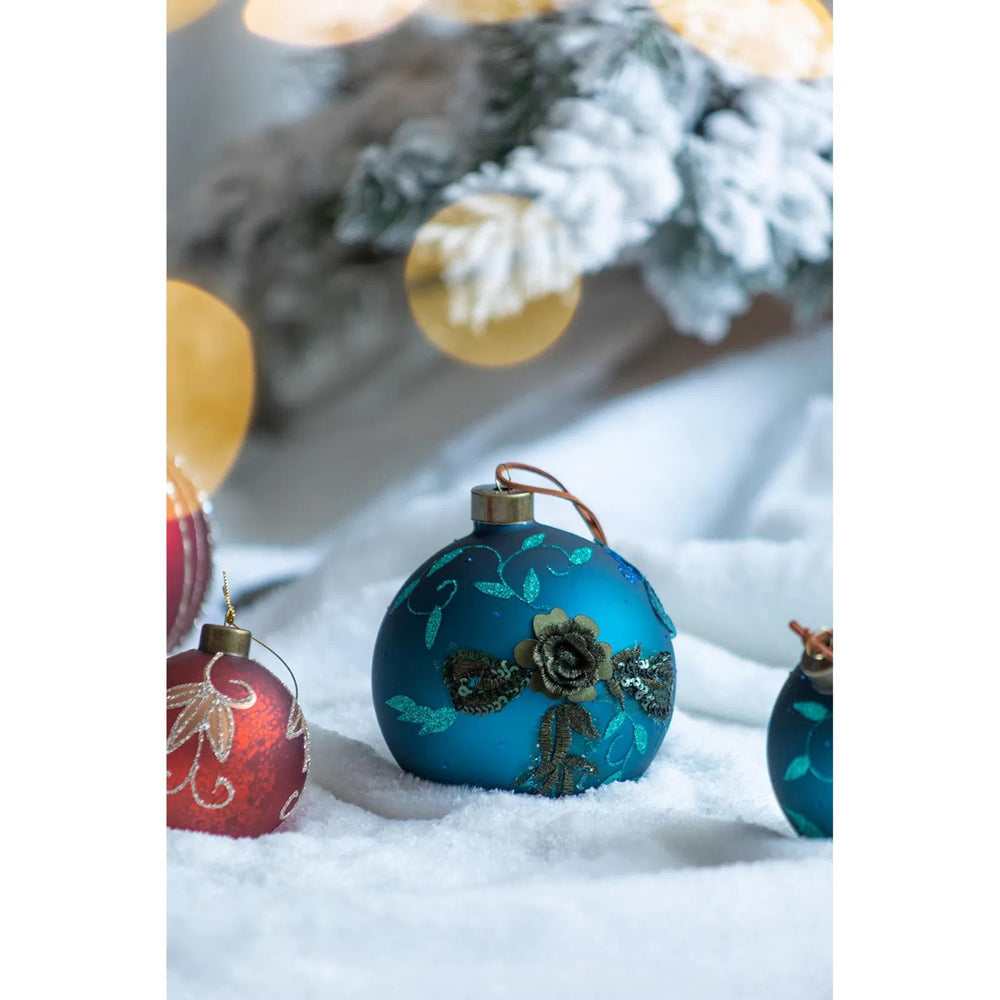 Vier petrolblauwe glazen kerstballen met glitter