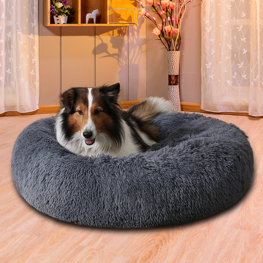 Hond ligt opgerold in een grijze donutmand