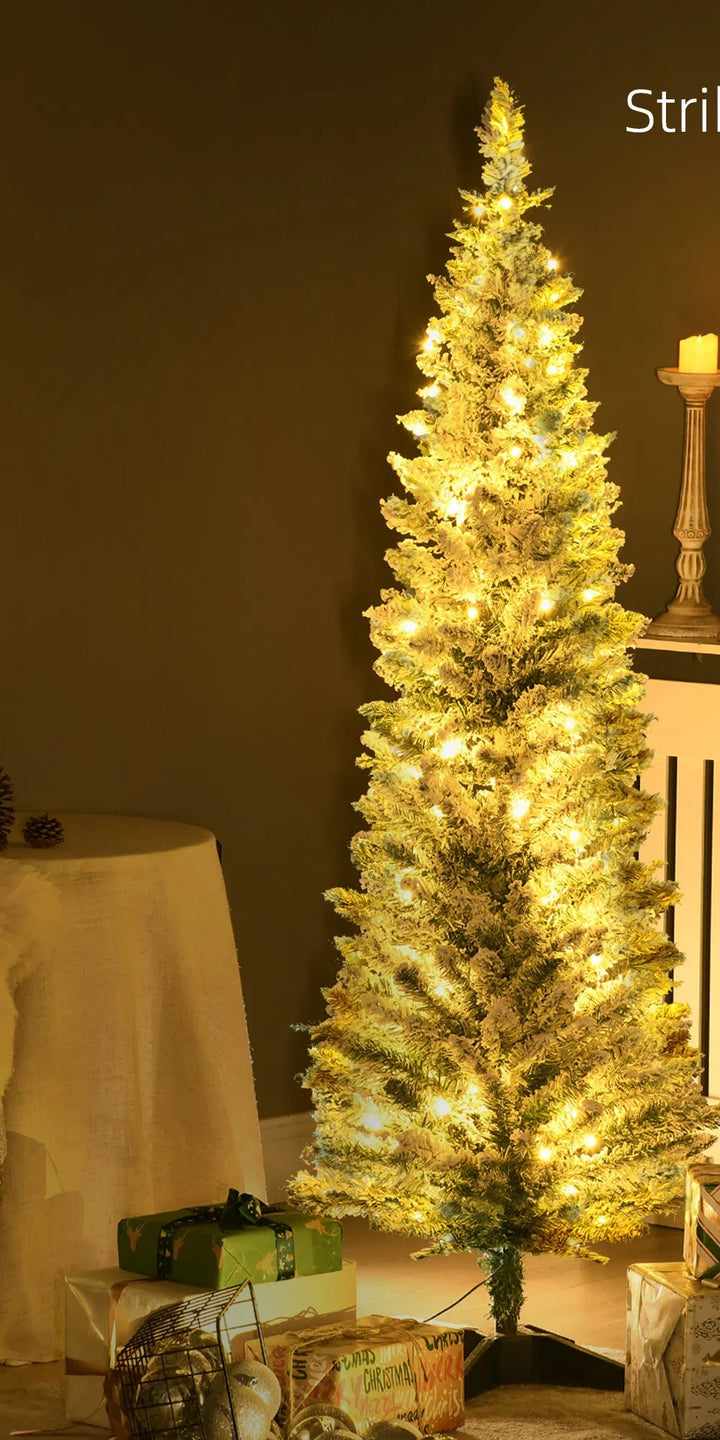 Besneeuwde smalle kerstboom met warme lichtjes