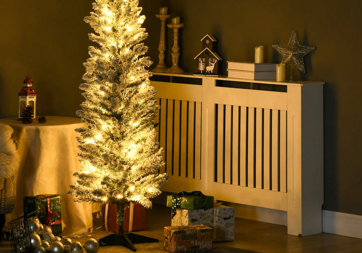 Smalle besneeuwde kerstboom met warmwitte lichtjes