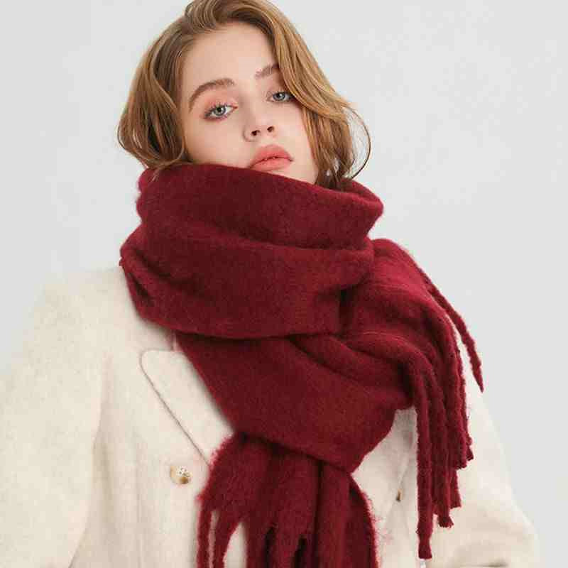 Vrouw met dikke wintersjaal met kwasten