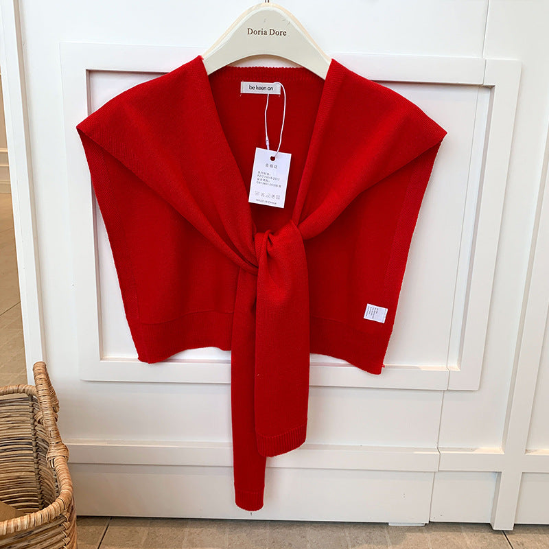 Vrouw met gebreide schouderdoek gestrikt