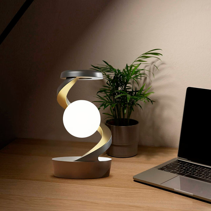 Draaiende maanlamp in metalen spiraal op bureau