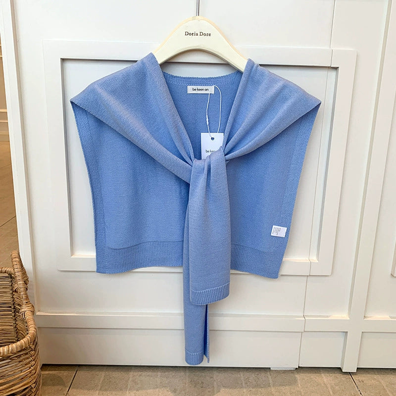 Vrouw met gebreide schouderdoek gestrikt