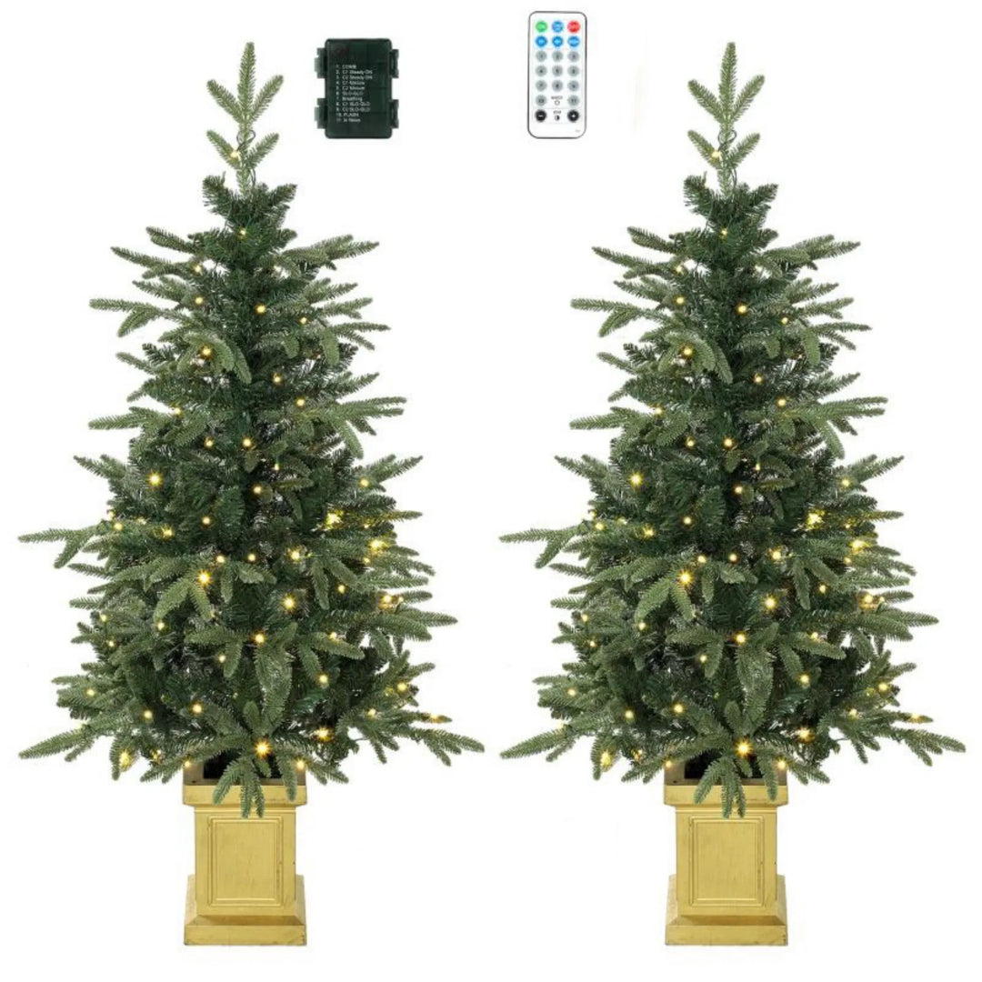 Twee kerstboompjes in gouden potten met lichtjes