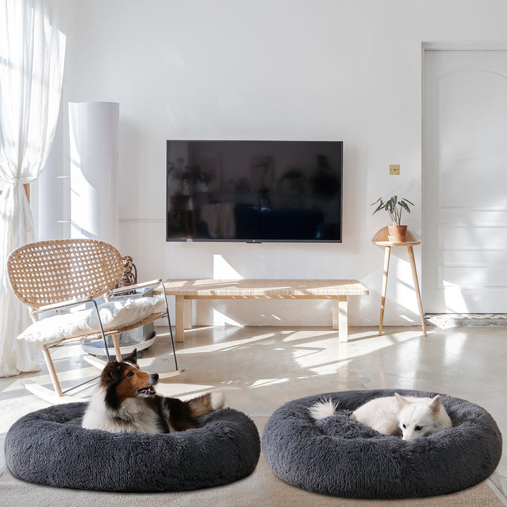 Hond ligt opgerold in een grijze donutmand