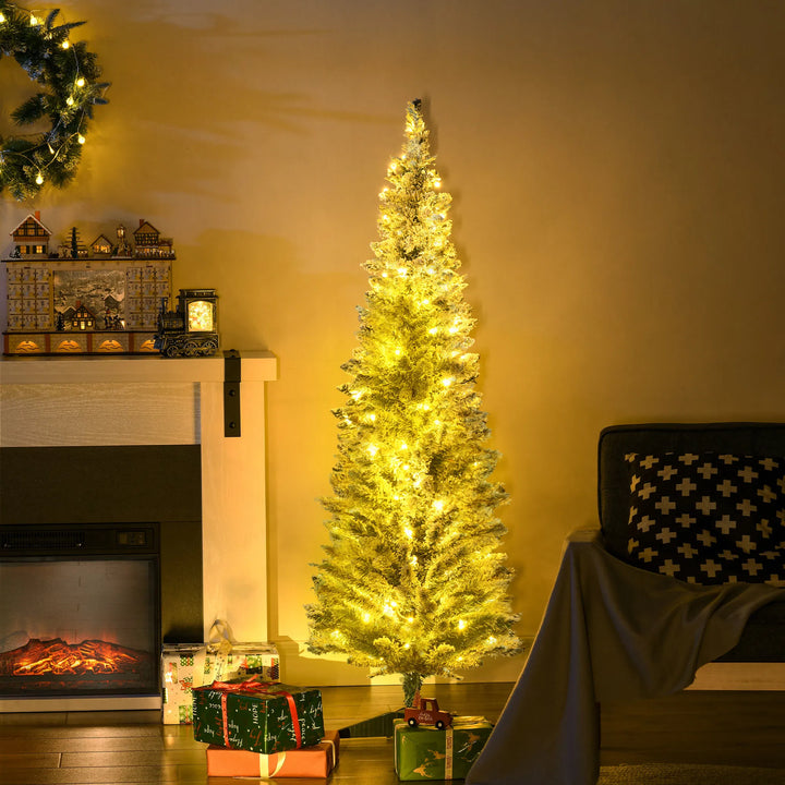 Besneeuwde smalle kerstboom met warme lichtjes