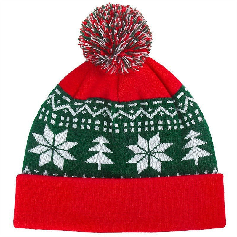 Gebreide kerstmuts met pompon en sneeuwvlokken